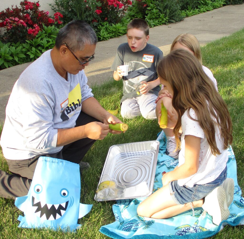 Group leader and his crew of kids having a snack at Vacation Bible School.